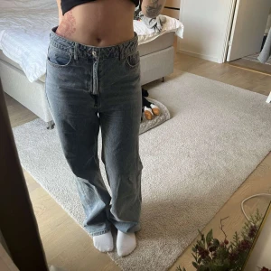 Blå jeans med hög midja - Säljer ett par snygga blå jeans med hög midja från H&M. De är i en straight fit och är riktigt bekväma. Perfekta för både vardag och fest! lite för stora för mig, därför jag säljer dem:)