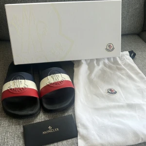 Moncler tofflor - Det är i väldigt fint skick nästan nya använda kanske 3-5 gånger  Ny pris 2000 