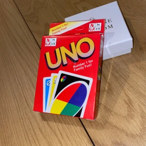 Helt ny, oöppnad UNO kortspel - Uno - ett klassiskt kortspel för vuxna och barn från 7 år. Spelet är enkelt att lära sig och roligt för alla åldrar. Innehåller 108 kort och instruktioner. Ett spännande spel för 2-10 personer. 