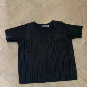 Svart t-shirt - Svart glansig ribbad t-shirt