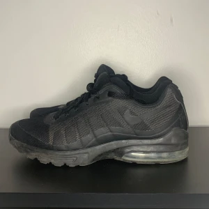 Svarta Nike Air Max sneakers - Säljer ett par svarta Nike Air Max sneakers i storlek herr 42,5. Skorna har en klassisk design med synlig Air Max-dämpning i sulan för extra komfort. De är tillverkade i ett slitstarkt material med snörning framtill. Perfekta för både vardag och träning.