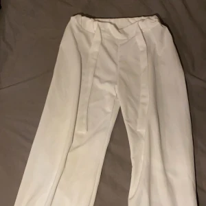 Vita kostymbyxor - Snygga vita kostymbyxor med hög midja och vida ben. Perfekta för en stilren look. Byxorna har en elegant passform och är tillverkade i ett mjukt material som ger en bekväm känsla.