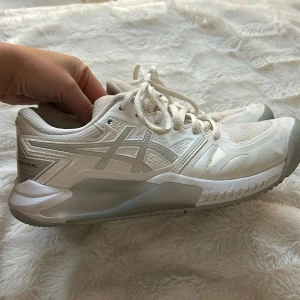 Vita Asics Gel-Challenger sneakers - Snygga vita Asics Gel-Challenger sneakers med snörning och grå detaljer. Perfekta för sport och träning med en bekväm passform och slitstark sula.