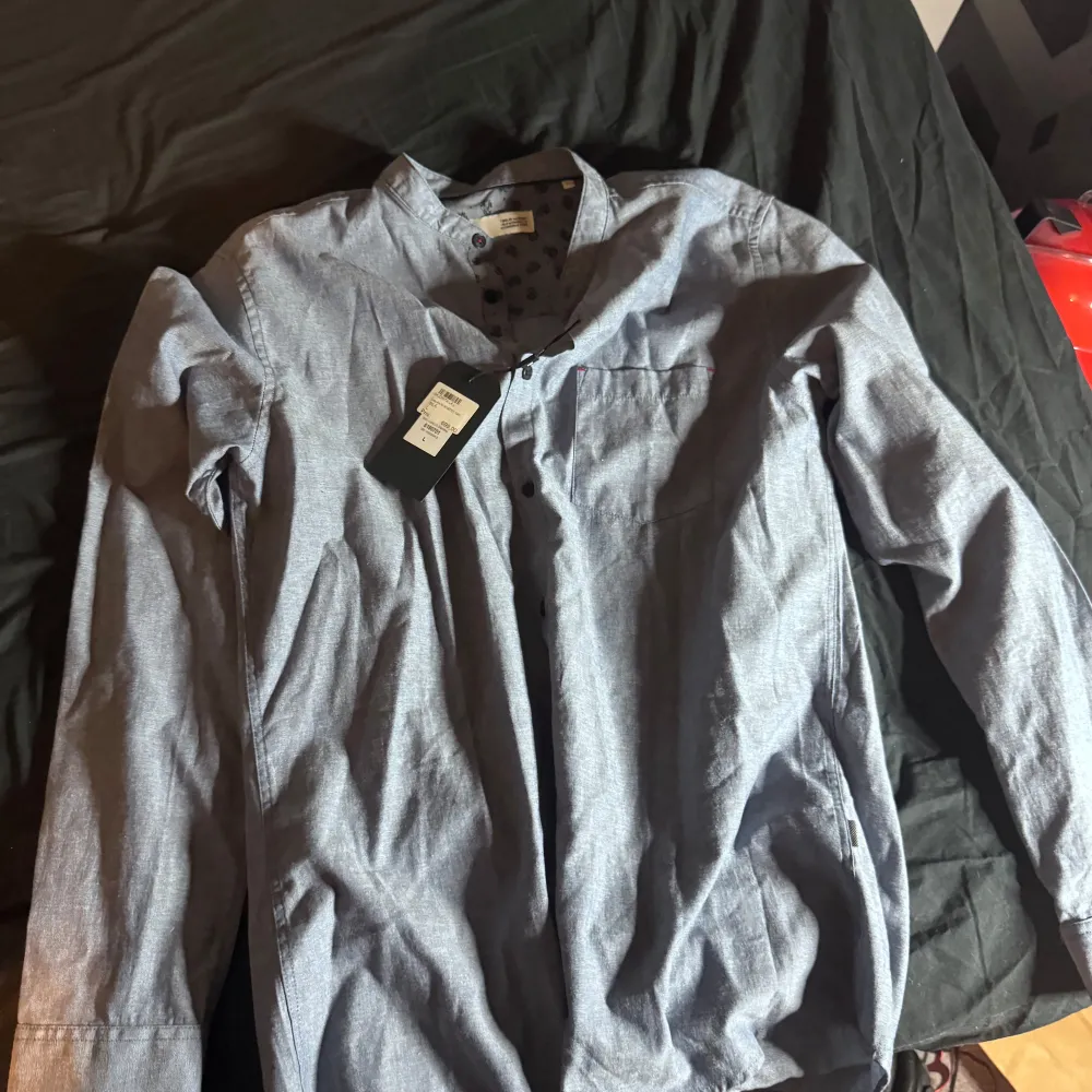 Snygg blå långärmad skjorta från Solid i storlek L. Skjortan har en klassisk design med knappar framtill och är tillverkad i ett bekvämt material. Perfekt för en stilren look. Aldrig använd . Paidat.