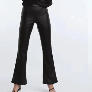 Svarta skinnbyxor med bootcut - Snygga svarta skinnbyxor med en trendig bootcut-stil. Perfekta för att ge en edgy touch till din outfit. Byxorna har en hög midja och en smickrande passform.