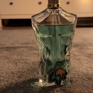 Jean Paul Gaultier Le Beau Eau de parfym  - Säljer en Jean Paul Gaultier Le Beau Eau de parfym med en unik flaska formad som en manlig torso. Doften är fräsch och förförisk med noter av bergamott, kokosnöt och tonkaböna. Flaskan är grön och kommer i en dekorativ blå förpackning med drakmotiv. Skriv om ni vill ha fler bilder 