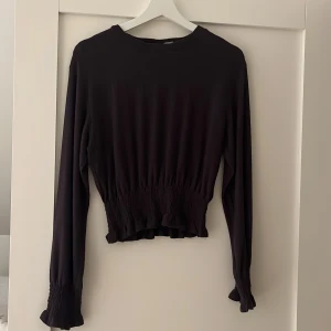 Topp - Jättefin svart topp från hm. Säljer då jag tyvärr inte använder den längre! Mudd/sitter åt, i midja och handleder vilket gör att den sitter väldigt fint! Hör av er vid fler bilder eller frågor!