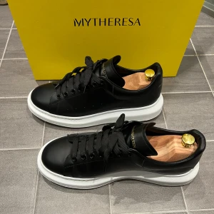 Alexander McQueen Oversized Sneaker - Snygga och populära svarta sneakers från Alexander McQueen med vit sula och klassisk snörning. Perfekta för en stilren look. Modellen slutsålda på den officiella hemsidan (5750 kr), och den nya modellen kostar 7580 kr (€660).