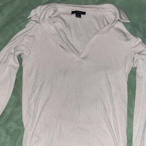 beige ribbad tröja - Säljer en beige ribbad tröja från Amisu. Tröjan har en v-ringad design och långa ärmar