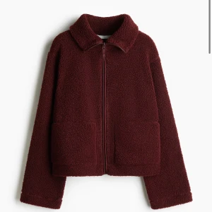 Vinröd teddyjacka med dragkedja - Pile teddy jacka från H&M. En nyhet men är redan slutsåld på hemsidan. Köpte i flera storlekar så därför jag säljer en här. Den är i storlek M men passar S. Tycker det är snyggt när den är lite oversize. Är 175cm och den är tillräckligt lång i armarna!