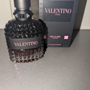 Valentino Uomo Born In Roma Intense 100 ml - Säljer en lyxig parfym från Valentino, Uomo Born In Roma Intense, i en elegant flaska med nitar och svart design. Doften är intensiv och maskulin, perfekt för den som vill sticka ut. Flaskan rymmer 100 ml och kommer i originalförpackning.