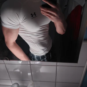 Vit kompressionströja från Under Armour - Säljer en vit kompressionströja från Under Armour med HeatGear-teknologi. Perfekt för träning med korta ärmar och en tight passform. Diskret logga på bröstet.