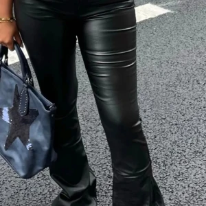 Svarta skinnbyxor med bootcut - Snygga svarta skinnbyxor med en trendig bootcut-stil. Perfekta för att ge din outfit en edgy touch. Byxorna har en tight passform upptill och vidgar sig vid anklarna. Säljer då inte passa mig💕