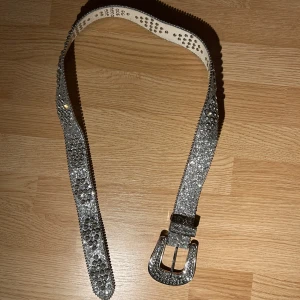 Glittrigt bälte med diamanter  - Snyggt glittrigt bb belt täckt med strass för en extra bling-effekt. Perfekt för att lyfta vilken outfit som helst. Bältet har en klassisk spänne i silverfärg och är justerbart för bästa passform. Det är inte ett äkta 😅