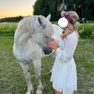 Vit blommig klänning - Charmig vit klänning med blommigt mönster och långa ärmar. Den har en smockad midja som ger en fin passform och en lätt v-ringad hals. Perfekt för somriga dagar och midsommarfirande! Bara använd 1 midsommar🌸