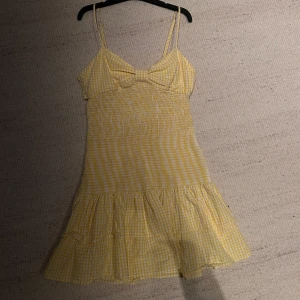 Trendig Zara klänning i storlek S - En fin gul rutig klänning med smala axelband och en söt rosett framtill, och en volangdetalj nere vid höften. Klänningen är aldrig använd men saknar prislapp. 💕