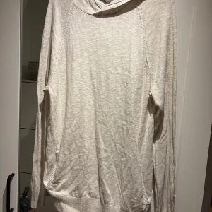 Beige tröja från Kenneth Cole Reaction - Säljer en stilren beige tröja från Kenneth Cole Reaction. Tröjan har långa ärmar och en avslappnad passform, perfekt för kyligare dagar. Den är tillverkad i ett mjukt material som ger en skön känsla mot huden.