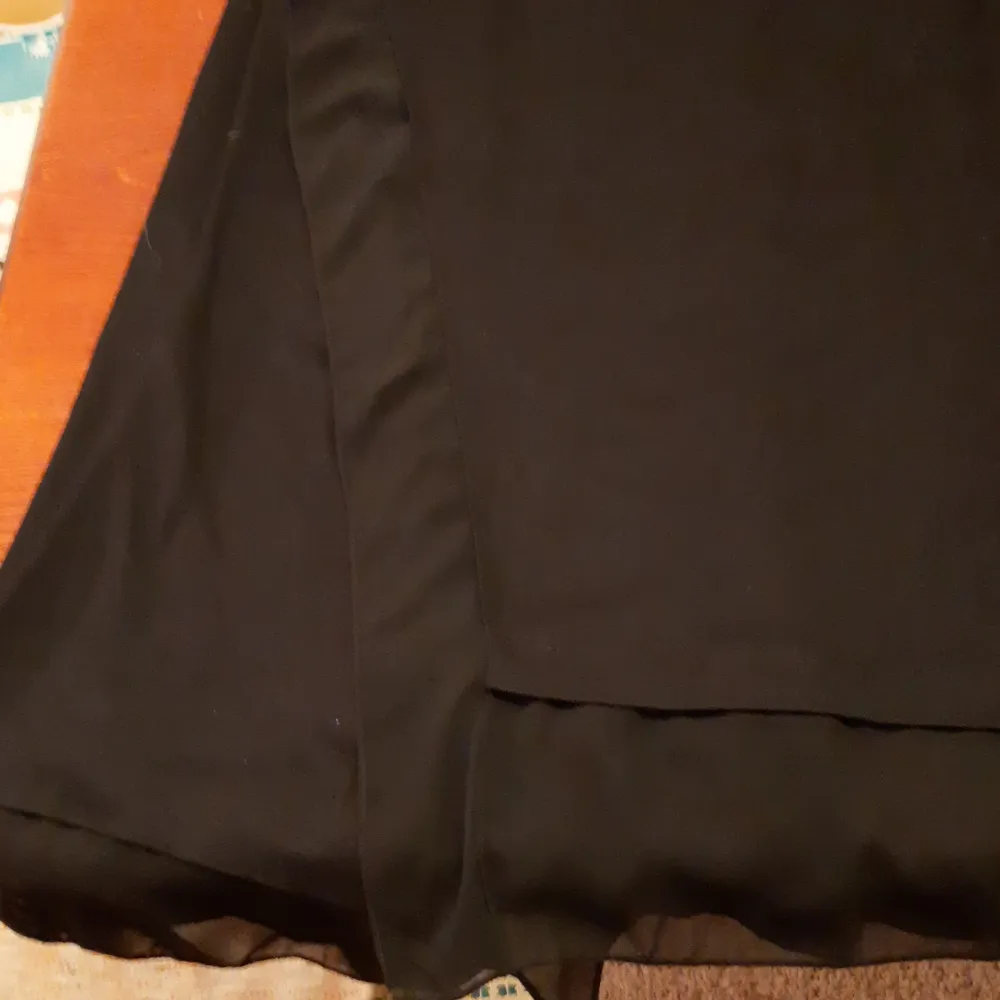 Elegant svart ärmlös utanpå väst eller kofta från LC Waikiki med en luftig design. Perfekt för en stilren look. Koftan eller västen har en asymmetrisk nederkant som ger en modern touch och du kommer att bli riktigt cool.. Muu.