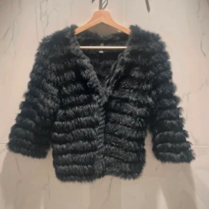 Svart pälsjacka - Snygg svart pälskofta med trekvartsärm, den är i jätte bra skick!! 
