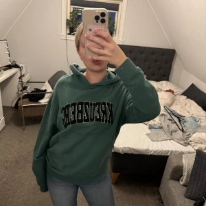 Mörkgrön hoddie med tryck  - Säljer min snygga mörkgröna hoddie med tryck som är ifrån asos, säljer pågrund av att den inte kommer till någon användning längre😊Hoodien är i ett mycket bra skick!! Passar till både tjej och kille👫