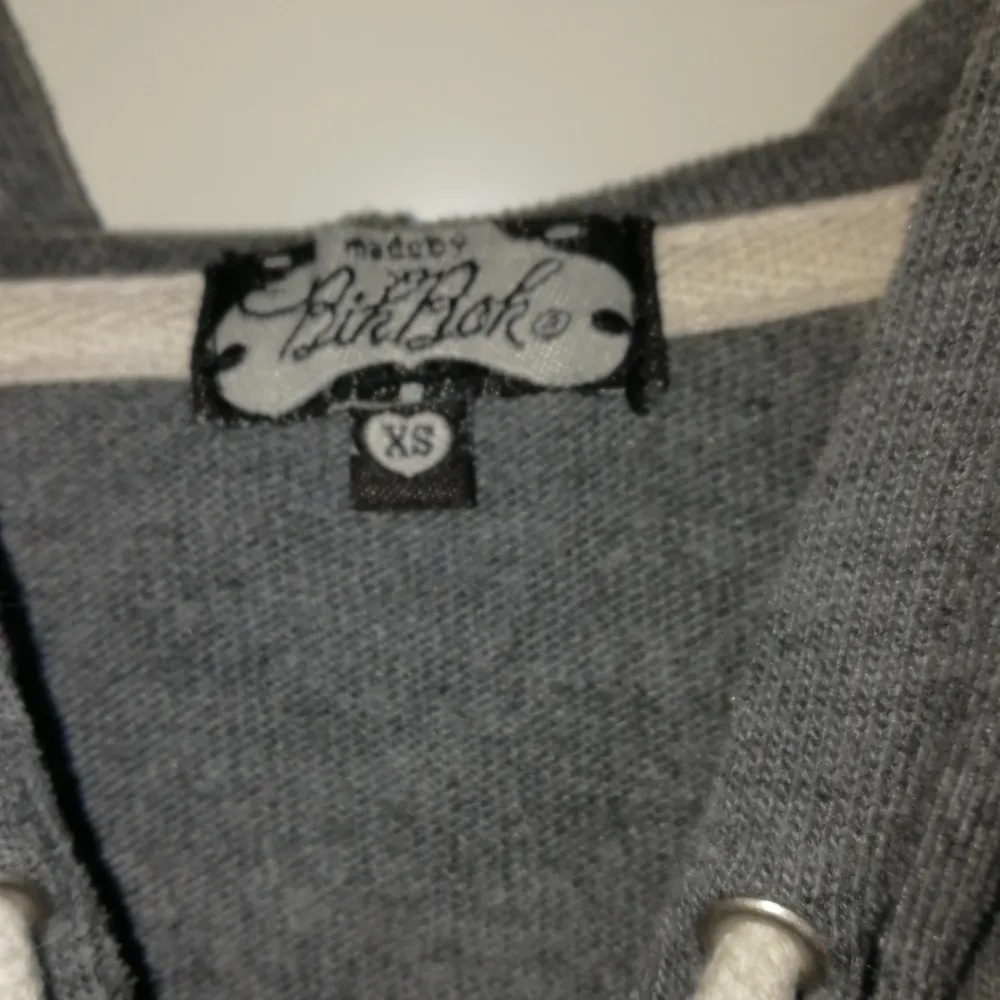 Mysig grå hoodie från Bik Bok med dragkedja och justerbar huva. Tröjan har trekvartsärmar och praktiska fickor framtill. Perfekt för en avslappnad stil.. Neuletakit & Villapaidat.