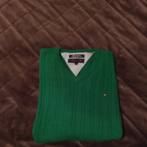 Grön tröja från Tommy Hilfiger - Säljer en snygg grön tröja från Tommy Hilfiger i storlek XXL. Tröjan är tillverkad i 100% bomull och användes aldrig tyvärr.