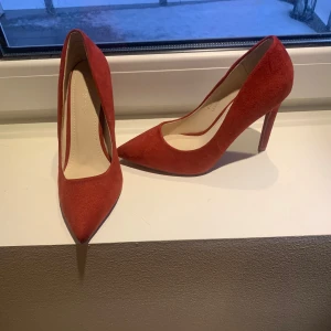 Röda mocka pumps - Snygga röda mocka pumps med spetsig tå och klack. Perfekta för att ge en färgklick till din outfit.