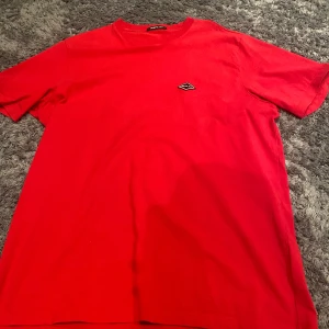 Röd t-shirt från Replay - Snygg röd t-shirt från Replay med en liten logga på bröstet. T-shirten har en normal passform och är kortärmad.