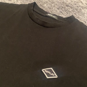 Svart t-shirt från Replay - Snygg svart t-shirt från Replay med en liten logga på bröstet. Gjord i mjukt material för extra komfort. 