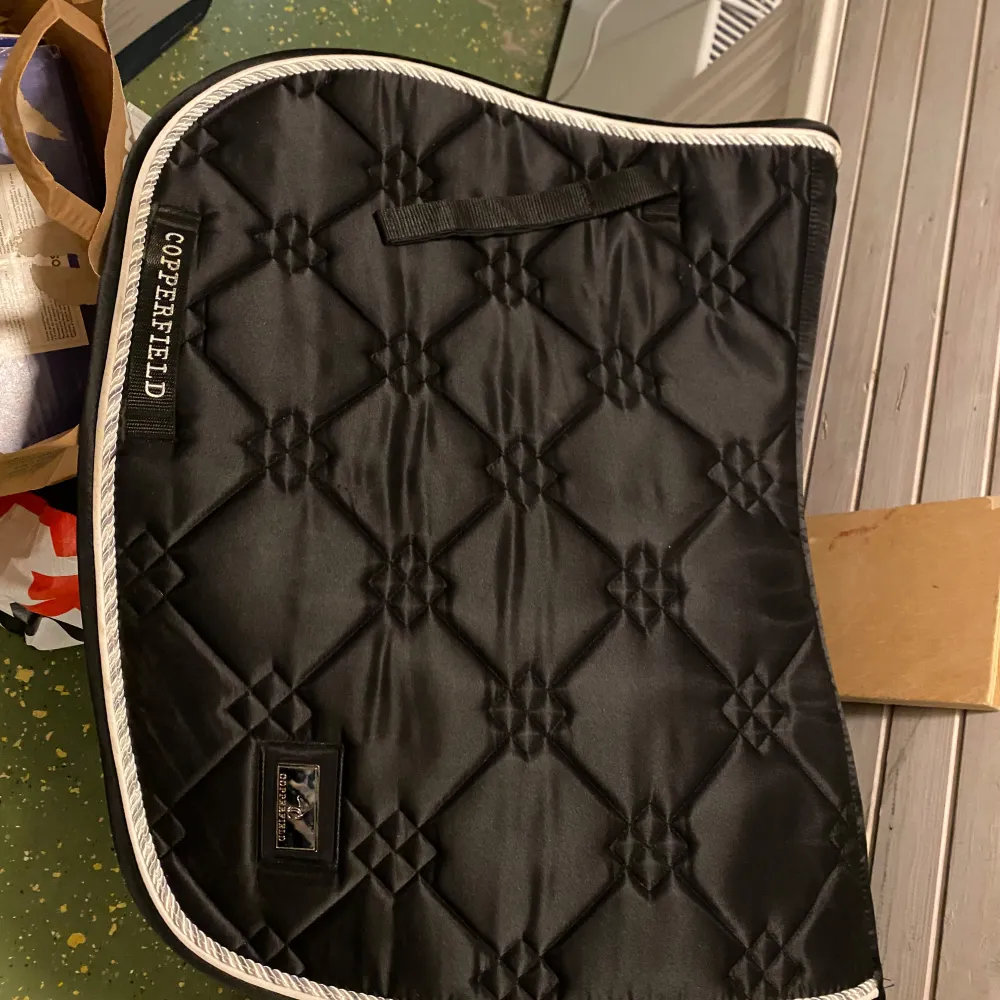 Snyggt svart schabrak från Copperfield med elegant quiltat mönster och vit kant. Perfekt för ridning och ger en stilren look till din utrustning. Använd ett par gånger och inte tvättat, har tyvärr inte möjlighet att tvätta det.. Muu.