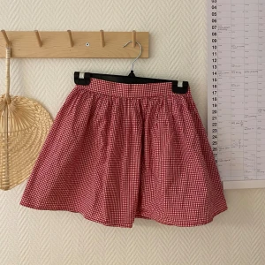 Rutig kort kjol  - Supergullig röd/vit-rutig kort kjol från american apparel! Resår och dragkedja baktill samt 98 % bomull❤️