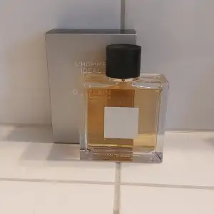 Säljer en elegant och stilren flaska av L'Homme Idéal L'intense från Guerlain. Flaskan är fyrkantig med en svart kork och en etikett i vitt. Parfymen har en varm och maskulin doft, perfekt för speciella tillfällen. Kommer med originalförpackning.