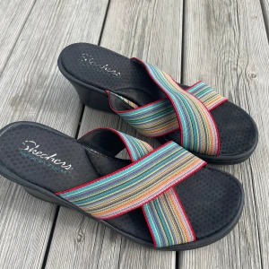 Skechers sandaletter med klack  - Skechers sandaletter med kilklack säljes. Väldigt mjuka med skön passform. Använda ett fåtal gånger (för höga för mig)