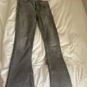 Ljusgrå low Waits bootcut jeans  - Jätte snygga ljus grå lågmidjade bootcut jeans ifrån Gina Tricot i storlek 152 så skulle säga att de passar xxs, pytteliten fläck på bild 4 men verkligen inget som syns  
