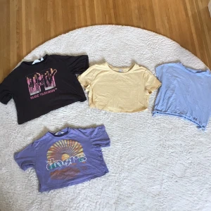 4 magtröjor från H&M (barnstorlek) - 1 ljusgul magtröja utan tryck, 1 ljusblå magtröja utan tryck, 1 ljuslila magtröja med "The doors" tryck och en mörkgrå magtröja med "music television" tryck. Alla från H&M. Alla tröjor för 25kr