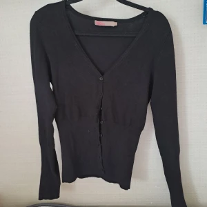 Svart kofta - Jättefin och skön kofta som tyvärr är för liten. Står att det är storlek S med skulle säga XS/S. Den ser ganska nopprig ut på bild två men i verkligheten är den inte så nopprig, ljuset i kameran förstärker utseendet av dom.