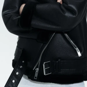 Svart skinnjacka med bälte - Säljer en snygg svart skinnjacka med bälte och dragkedja. Jackan har en cool och edgy stil med långa ärmar och en mjuk insida. Perfekt för höst och vinter! Har använt den max 4 gånger 