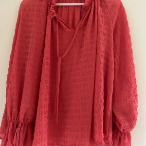 Röd fin blus - Super fin röd/aprikos färgad blus med snören! Från märket Stockholm Lm, passar perfekt till en mysig höst middag!❣️