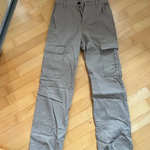 Beige cargobyxor - Säljer ett par snygga beige cargobyxor med flera praktiska fickor. Perfekta för en avslappnad och cool stil. Byxorna har en normal passform och är gjorda i ett slitstarkt material.