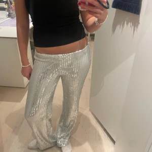 Silvriga paljettbyxor - Såå snygga byxor till nyår!😍✨🪩  Byxorna är oanvända och har kvar prislappen, man kan justera midjan beroende på hur low rised man vill ha dem! Postar direkt