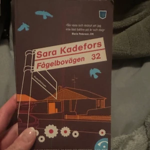 Fågelbovägen 32 - Boken 'Fågelbovägen 32' av Sara Kadefors har ett omslag i brunt med illustrationer av ett hus och fåglar. Citat från Marie Peterson, DN, finns på framsidan. Perfekt för dig som gillar svensk samtidslitteratur.