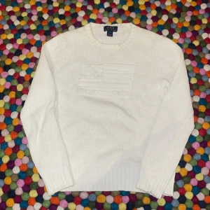 Vit stickad tröja från Polo Ralph Lauren - Säljer en stilren vit stickad tröja från Polo Ralph Lauren. Tröjan har en klassisk design med ribbade muddar och rund hals. Perfekt för en elegant och avslappnad look.