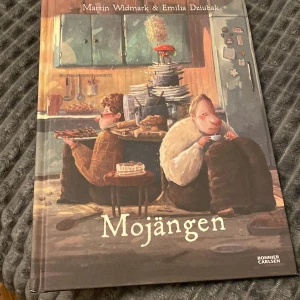 Mojängen - Boken 'Mojängen' av Martin Widmark och Emilia Dziubak handlar om Rutger och Valter som bygger en robot. Den är rikt illustrerad och berättar en humoristisk historia om längtan och teknik. Perfekt för barn som älskar äventyr och uppfinningar.