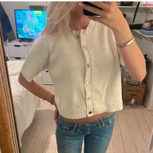 Vit ribbad kofta - Säljer en stilren vit ribbad kofta med korta ärmar och knappar framtill. Perfekt till både skolan och utanför. Passar bra till jeans eller kjol.💕