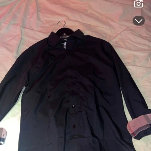 Svart skjorta från Burberry - Snygg svart skjorta från Burberry med klassisk krage och broderad logga på bröstet. 