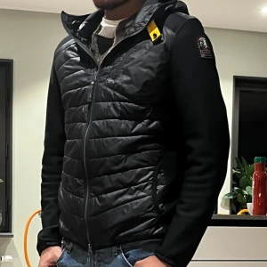 Parajumpers Nolan Hybrid  - Snygg svart jacka från Parajumpers. Jackan är inköpt för 4999kr ett år sedan och är i perfekt skick förutom att sömnen i armen har lossnat lite, det är absolute inget man lägger märket till. Hör gärna av er vid fler frågor eller funderingar!😄 Storlek:S