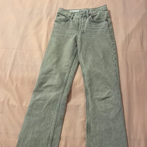 Grå jeans från Zara - Snygga grå jeans från Zara med en klassisk femficksdesign. De har en rak passform och är tillverkade i ett bekvämt denimtyg. Perfekta för en stilren vardagslook.