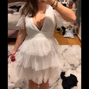 Vit student klänning med volanger - Studentklänning!! Från Showpo, helt ny har inte använt! De var för liten för mig så jag säljer den! Storlek 34 så de passar för Xs och S. Original pris 1200 säljer 700!  Prisen kan diskuteras!                                        Charmig vit klänning med flera lager av volanger och en djup v-ringning. Klänningen har korta ärmar i ett luftigt material som ger en romantisk känsla. Perfekt för sommarens festligheter.