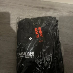 Askari Sweat/sauna suit original limited edition  - Säljer en svart sweatsuit från Askari med stor logga på både framsidan och baksidan. Jackan har en huva och dragkedja framtill. Perfekt för blåsiga dagar och har en sportig look. Har 2 st den första bilden är den som säljes. Original sauna suit går ej att köpa längre, varken öppnad eller använd orginalpris 1300kr 