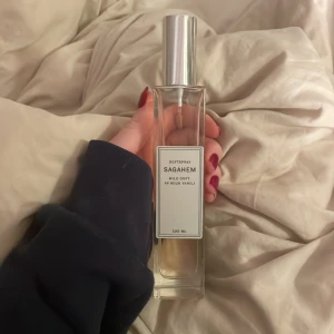 Doftspray Sagahem - Säljer en elegant doftspray från Sagahem med en mild doft av vanilj. Det är en doftspray till kläder eller rummet, så vill du ha en parfym till kroppen är denna inte för dig. Flaskan är stilren och rektangulär med en silverfärgad kork. Innehåller 100 ml av denna ljuvliga doft som passar perfekt för en fräsch känsla i rummet. Den är använd ett fåtal gånger som ni ser på bild 2.